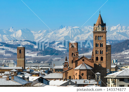 European town with snow-covered rooftops and medieval towers against a snow-capped Alps, in Italy. European town with snow-covered rooftops and medieval towers against a snow-capped Alps, in Italy. 143374877