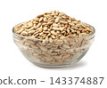 Roasted sunflower seeds in a glass bowl on a white background. Isolated 143374887
