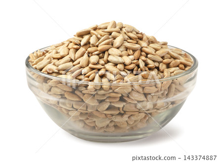 Roasted sunflower seeds in a glass bowl on a white background. Isolated Roasted sunflower seeds in a glass bowl on a white background. Isolated 143374887