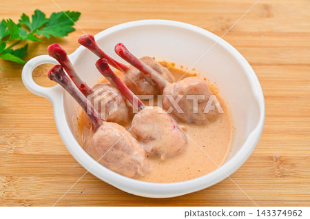 Preparing the tulip-shaped fried chicken by coating it in batter. 143374962