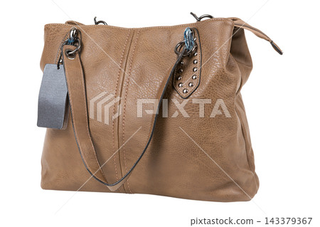 Stylish taupe leatherette women handbag with shoulder straps and tag isolated on white background Stylish taupe leatherette women handbag with shoulder straps and tag isolated on white background 143379367