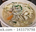 特寫鏡頭：鹽味拉麵，上面鋪滿了蔬菜和擔擔面，盛在白色碗中。 143379798