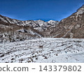 湛藍的天空映襯著白雪皚皚的山巒和山谷，構成了一幅冬日山景的全景圖。 143379802