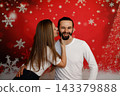 Playful couple flirting on festive Christmas background 143379888