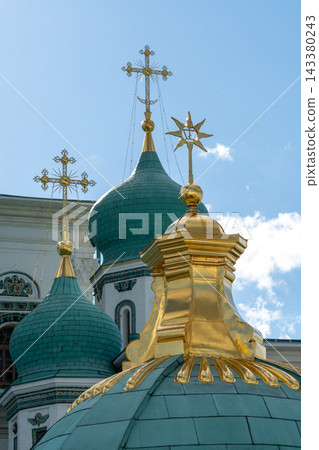Golden Orthodox Church Domes and Crosses Against Blue Sky With Dramatic Clouds Golden Orthodox Church Domes and Crosses Against Blue Sky With Dramatic Clouds 143380243
