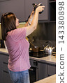 Woman photographing a modern kitchen with a digital camera 143380898
