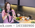 Woman taking food photo with DSLR camera in kitchen 143380900
