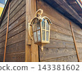 A gilded antique style lantern hangs on the wooden wall 143381602
