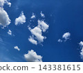 On a spring day, whimsical white clouds drift across the blue sky. 143381615