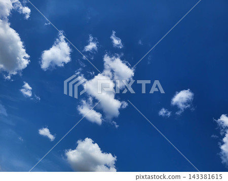 On a spring day, whimsical white clouds drift across the blue sky. On a spring day, whimsical white clouds drift across the blue sky. 143381615