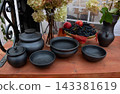 Black clay pots and bowls are standing on the table 143381619