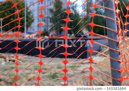 Orange Plastic Safety Net Barrier Around Construction Site for Danger Caution Concept Orange Plastic Safety Net Barrier Around Construction Site for Danger Caution Concept 143381664