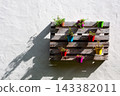 Vertical garden made with a wooden pallet and colorful flower pots 143382011