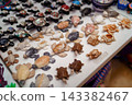 Carved stone and abalone shell turtle souvenirs on market table 143382467