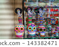 Colorful day of the dead catrina figurines and painted sugar skulls 143382471