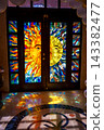 Sunlit stained glass doors with sun and moon faces 143382477
