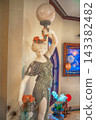 Marble statue of woman holding globe lamp and basket of roses 143382482
