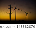 Wind turbines and power lines silhouette at sunset 143382870