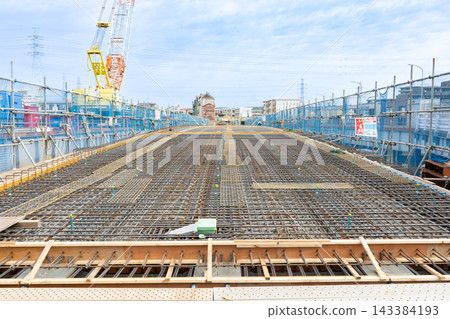 Reinforcement work for the bridge deck slab over the river, where steel bars are arranged in a grid pattern. Reinforcement work for the bridge deck slab over the river, where steel bars are arranged in a grid pattern. 143384193