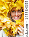 Portrait of a young woman wearing a handmade maple leaf wreath in an autumn park. Fall leaves, seasonal lifestyle, outdoor wellness and colorful foliage create a cozy autumn portrait. 143384355