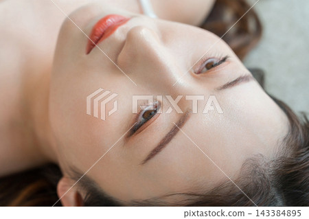 一張女性臉部特寫，突出了她迷人的眉毛和眼睛。這是一張展現女性美感的照片，重點在於突出了她的眉毛和光滑美麗的肌膚。 143384895