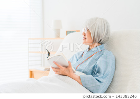 一位頭髮花白的老婦人住院了,正在病房裡看書。 一位頭髮花白的老婦人住院了,正在病房裡看書。 143385246