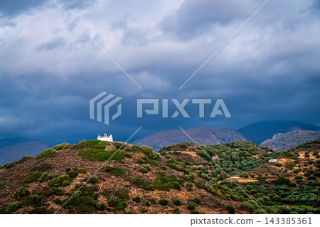 Small white chapel beneath storm clouds, eastern Crete, Greece 143385361