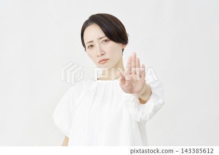 Middle-aged woman in a stop pose against a white background. Middle-aged woman in a stop pose against a white background. 143385612