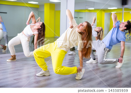 Young girl training breakdance drops in dance hall Young girl training breakdance drops in dance hall 143385939