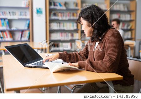 Asian girl with teenagers students studying in school library Asian girl with teenagers students studying in school library 143385956