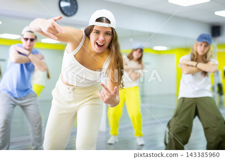 Young girl in cap training breakdance Toprock moves in dance hall 143385960