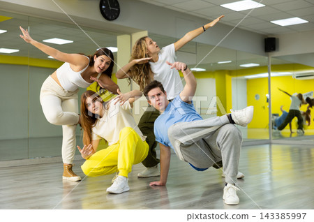 Group portrait of cheerful, talented and active tween dancers in casual clothes posing together in fitness studio Group portrait of cheerful, talented and active tween dancers in casual clothes posing together in fitness studio 143385997