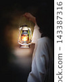 Jesus Christ guiding the way, holding a bright lantern in the darkness. 143387316