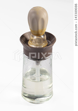 Glass dropper bottle with clear liquid and brown rubber seal, featuring frosted glass bulb and plastic pipette for precise dispensing Glass dropper bottle with clear liquid and brown rubber seal, featuring frosted glass bulb and plastic pipette for precise dispensing 143389086