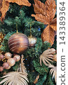 Christmas ball on tree. Closeup on Christmas tree decoration over festive background 143389364