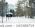 cozy log cabin in snowy countryside setting surrounded by evergreen trees and mountains. The scene evokes a sense of tranquility and mindfulness. 143389719