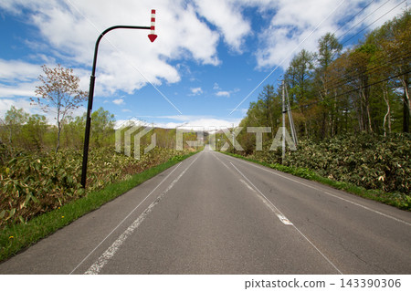 一條鄉村公路,可以俯瞰白雪皚皚的山脈:典型的日本山地景觀。 一條鄉村公路,可以俯瞰白雪皚皚的山脈:典型的日本山地景觀。 143390306