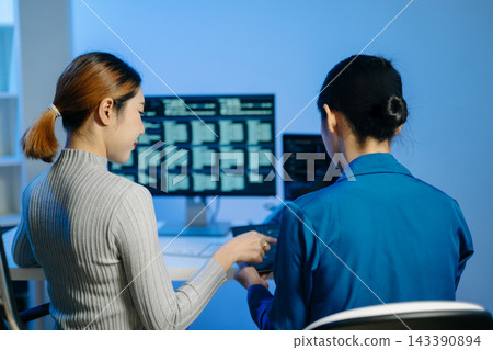 Women programmers working with code, laptop, computer screens and digital interfaces in a modern technology workspace, showing teamwork Women programmers working with code, laptop, computer screens and digital interfaces in a modern technology workspace, showing teamwork 143390894