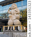大黑天（財富和繁榮之神）的石像矗立在日本寺廟或神社中，與現代建築並肩而立。 143391323