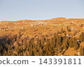 Golden autumn sunset over mountain slopes covered with pine forest and dry grass 143391811