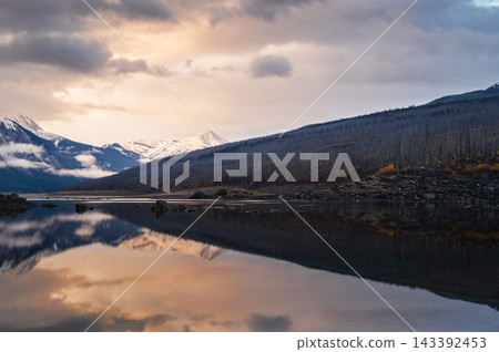 Serene lake reflection captures dramatic sunset sky above mountain wilderness in scenic canada providing deep tranquil harmony Serene lake reflection captures dramatic sunset sky above mountain wilderness in scenic canada providing deep tranquil harmony 143392453