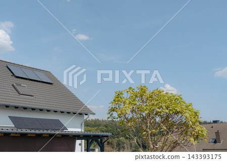 solar panels installed stationary on a residential roof, surrounded by clear skies and greenery, creating a peaceful and eco-friendly environment for sustainable home improvement with blue. 143393175