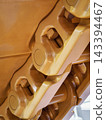 Detailed view of machinery components showing a yellow mechanism used in construction or heavy equipment 143394467