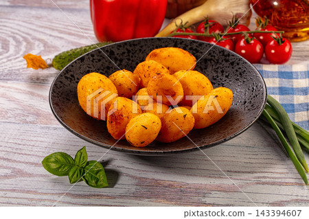 Rustic wooden table with roasted baby potatoes in dark ceramic bowl, fresh tomatoes, paprika, cucumber and basil around, homemade vegetarian food Rustic wooden table with roasted baby potatoes in dark ceramic bowl, fresh tomatoes, paprika, cucumber and basil around, homemade vegetarian food 143394607