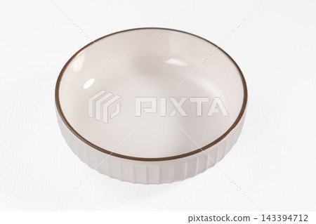 Brown rimmed ceramic ramekin, white fluted bowl, kitchen tableware Brown rimmed ceramic ramekin, white fluted bowl, kitchen tableware 143394712
