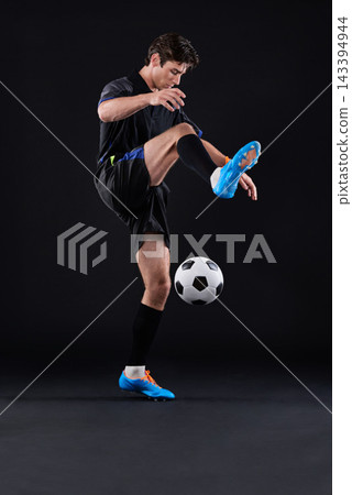 Skill, football and man with fitness in studio for sports training with exercise isolated on black background. Technique, talent and professional soccer player in Poland with ball control for career. Skill, football and man with fitness in studio for sports training with exercise isolated on black background. Technique, talent and professional soccer player in Poland with ball control for career. 143394944