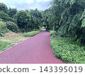 A red promenade surrounded by greenery 143395019