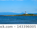A white and black lighthouse standing in the sea 143396005