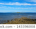 The northern lighthouse stands on a small island offshore. 143396008