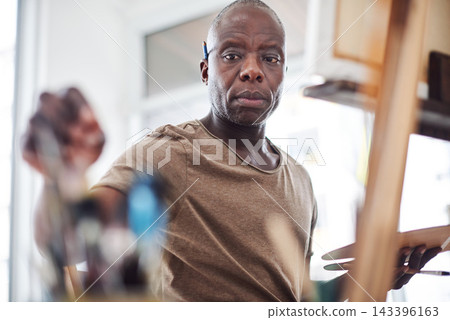 Black man, artist and paintbrush for easel painting or small business project, career or equipment. Male person, creativity and color palette for craft hobby or art therapy class, relax or picture Black man, artist and paintbrush for easel painting or small business project, career or equipment. Male person, creativity and color palette for craft hobby or art therapy class, relax or picture 143396163